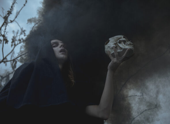low-view-man-holding-skull-black-fog