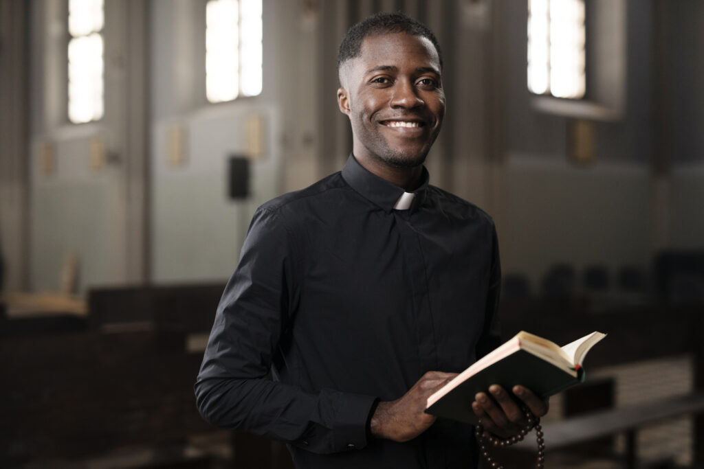 young-male-priest-holding-holy-book-church